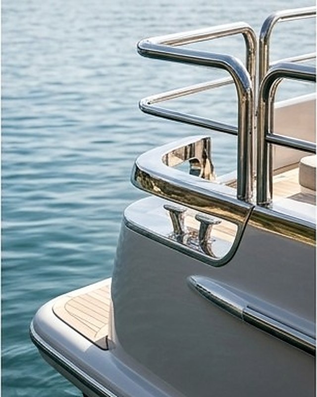 Stainless boarding rails and teak swim platform above clear green water