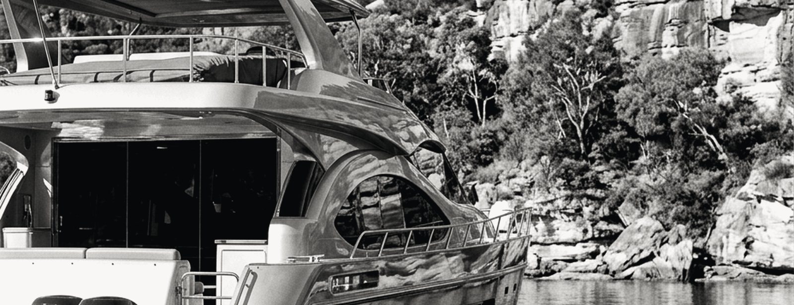 Motor cruiser at rest on Sydney Harbour with the Opera House and Harbour Bridge behind