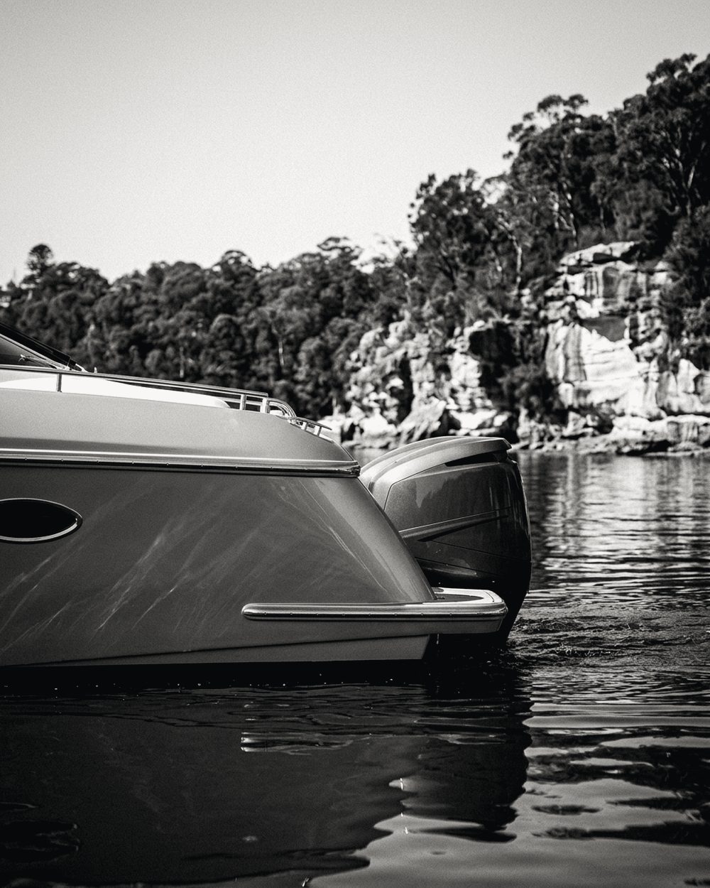 Large flybridge motor yacht moored against sandstone cliffs