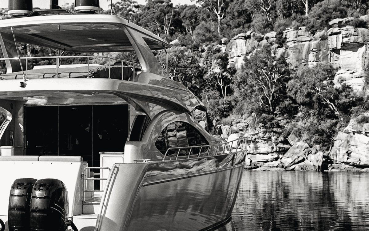 Motor cruiser moored in a quiet Sydney bay beneath sandstone cliffs