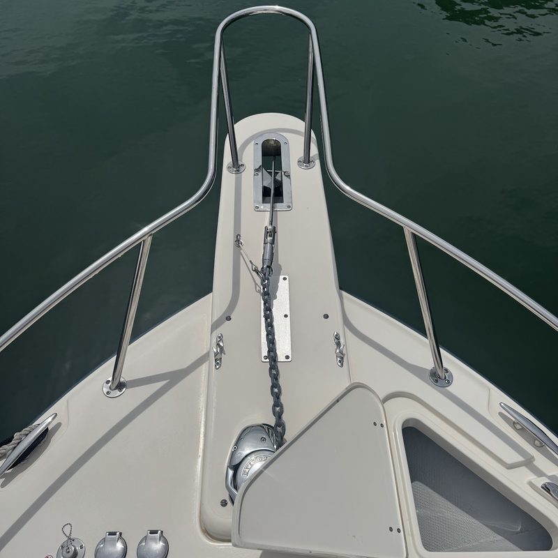 Looking forward along the foredeck of a cruiser to the anchor and bow rail