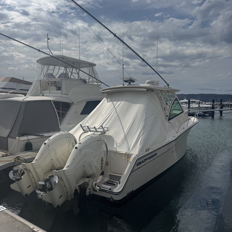 Covered cruiser with twin outboards in its marina berth