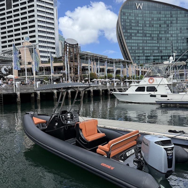 Black RIB with orange seats tied up at a city marina