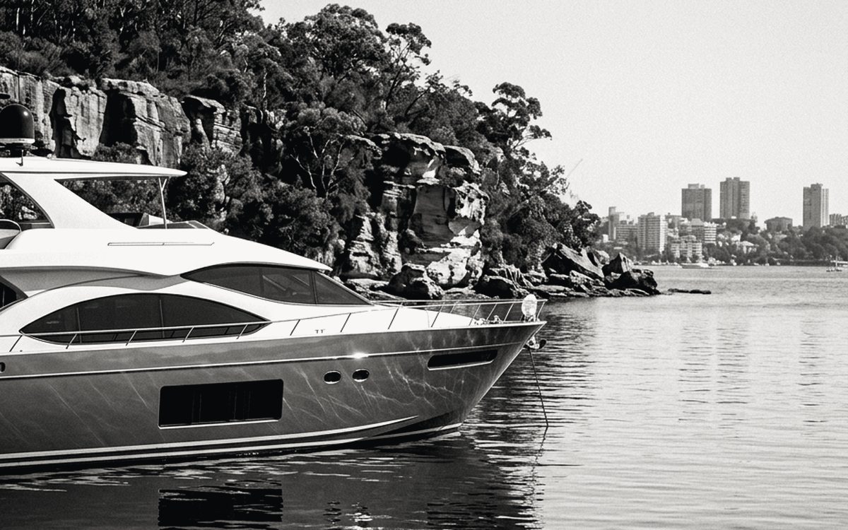 Managed motor cruiser moored against sandstone cliffs on Sydney's Middle Harbour